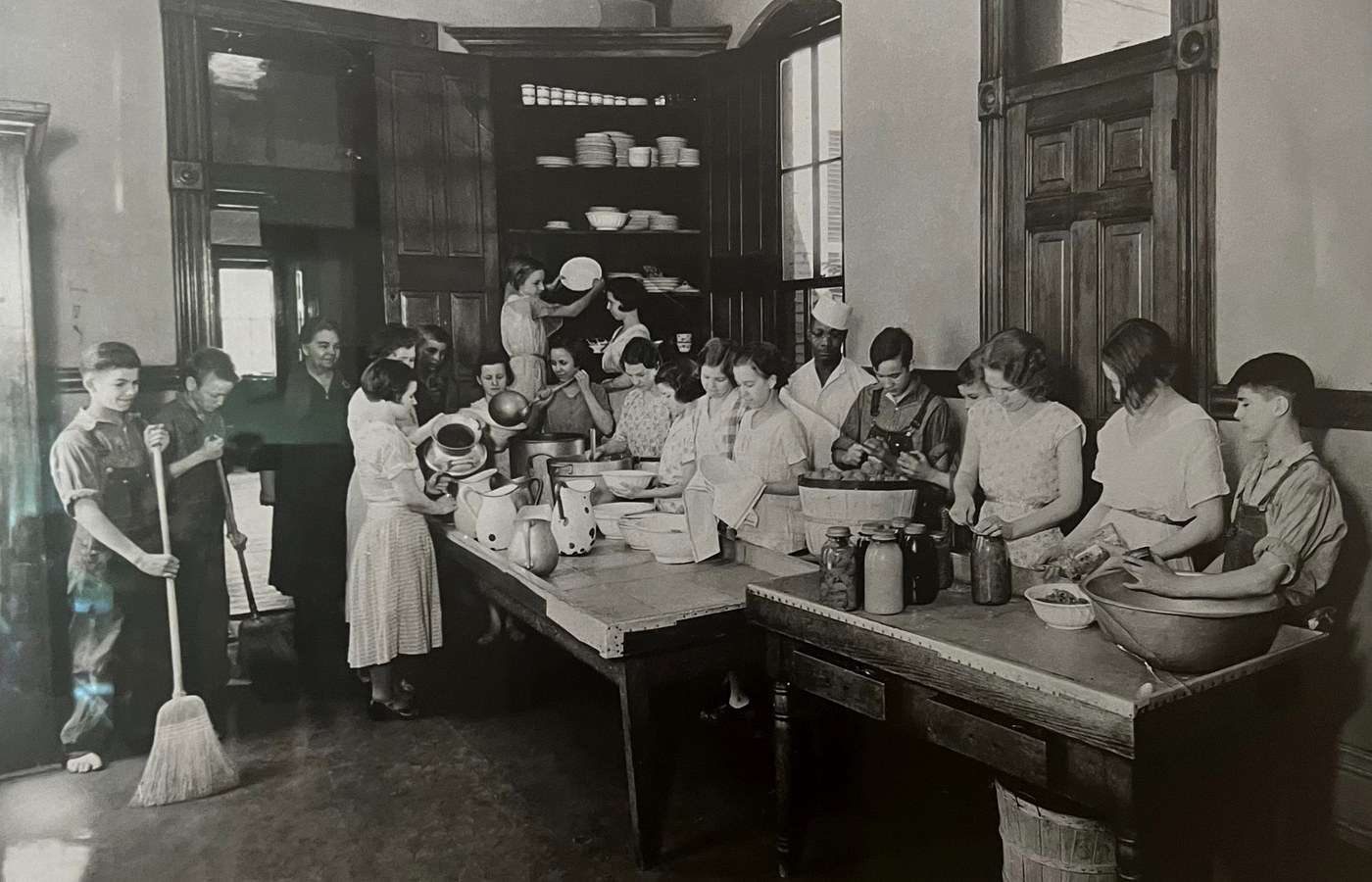 Historic kitchen scene with children and staff