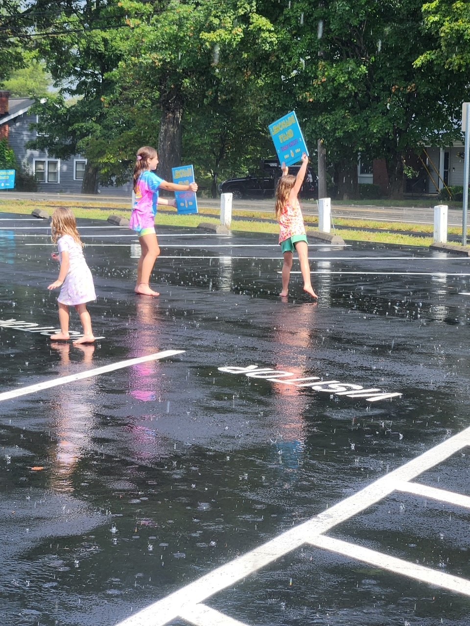 Girls promoting the lemonade stand despite the rainy weather